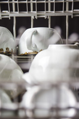 Clean cups in the dishwasher. Home equipment. Blue Rustic Tableware