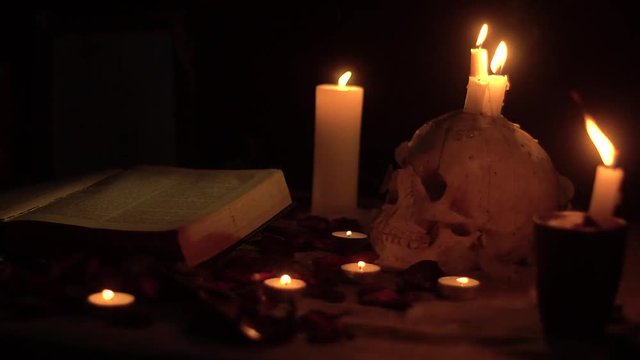 Flashing candle fire on the skull and around the magic book