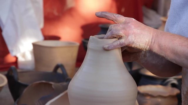 Alfarera acabando una vasija de barro de estilo tradicional en el torno