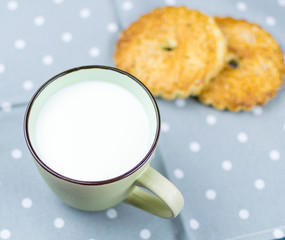 Large cup with milk and cookies in the background.