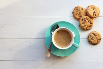 Coffee in a turquoise mug and cookies on a white table the top view - Powered by Adobe