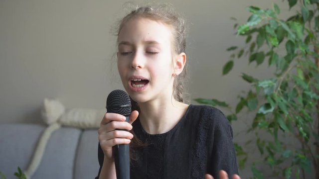Cute little girl singing karaoke at home.