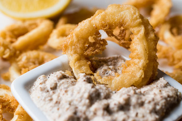 Fried Crispy Calamari Squid Rings with Tartar Sauce and Lemon.