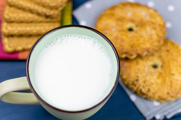 Large cup with milk and cookies in the background.