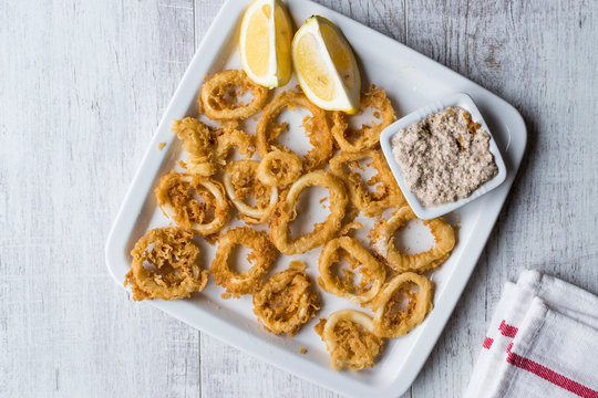 Fried Crispy Calamari Squid Rings with Tartar Sauce and Lemon.