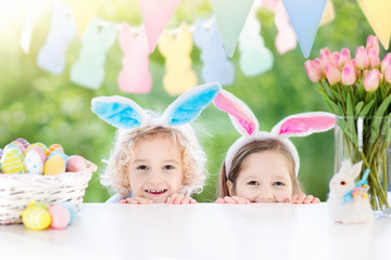 Naklejka premium Kids with bunny ears and eggs on Easter egg hunt.