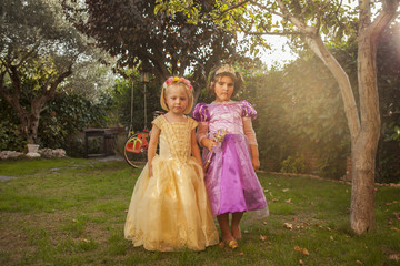 Obraz na płótnie Canvas Children in princess costumes playing in the garden. Outdoors.
