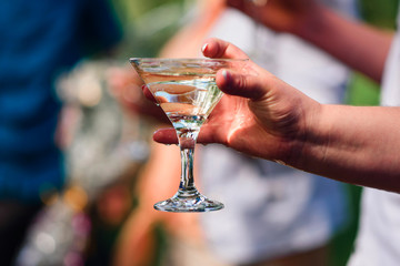 women's hand with a glass of Martini close-up at the festival