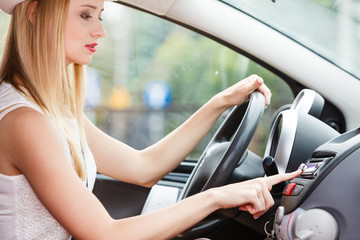 Fototapeta na wymiar woman changing radio station in her car