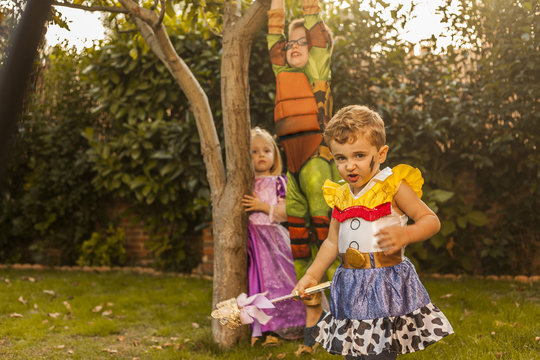 Kids with costumes playing in the garden. Outdoors.