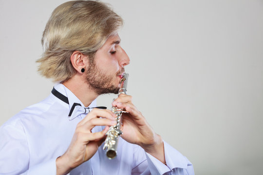 Male flutist playing his flute