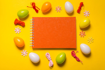 Blank notebook and Easter decor on yellow background
