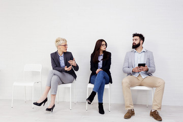 Obraz premium Three people talking to each other while waiting for job interwiev