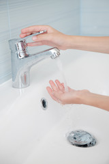 close-up of hands of a child in the bathroom under the tap water