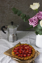 Dining table with flowers, coffee maker and strawberry pie, rustic style