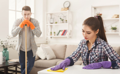 Young couple cleaning home together