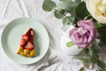 Dining table with flowers and strawberry pie, rustic style