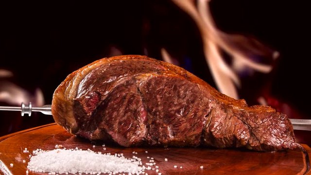 Meat Alcatra, traditional Brazilian barbecue with fire background.