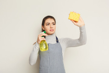 Young woman washing wall with sponge