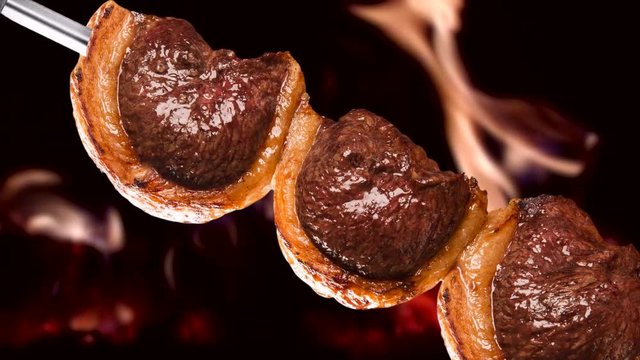 Picanha, traditional Brazilian barbecue with fire background.