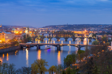 Fototapeta na wymiar Old town and bridges over Vltava river illuminated night view from Letenske garden. Prague, Czech Republic