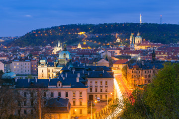 Fototapeta na wymiar Old town and Petrin hill illuminated night view from Letenske garden. Prague, Czech Republic