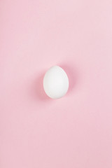 White egg on pink background. Top view