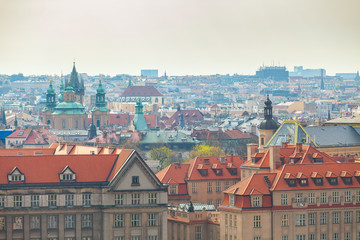 Fototapeta na wymiar Prague rooftops. Beautiful aerial view of historic center area architecture with red roofs and modern buildings on the background
