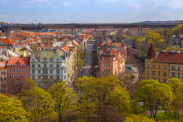 Fototapeta na wymiar Prague streets with old living blocks red rooftops with park and trees