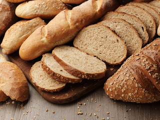 Fresh bread with spikelets of wheat on a wooden background