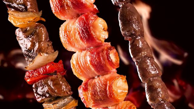 Assorted steak skewers on a fire background