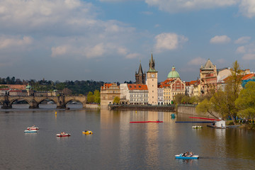 Naklejka premium Widok na Wełtawę z łodziami. Stare Miasto w Pradze, Czechy, sezon letni.