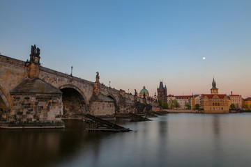 Charles bridge at deep sunset. Smooth water surface shot with long exposure.