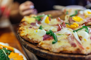 Boiled egg cheese pizza that pick slices with stretching cheese at the restaurant in Sa PA, Vietnam.