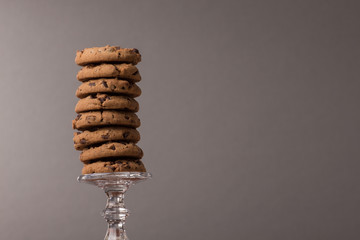 mehrere Cookies gestapelt auf einem elegantem Glas vor dunklem Hintergrund