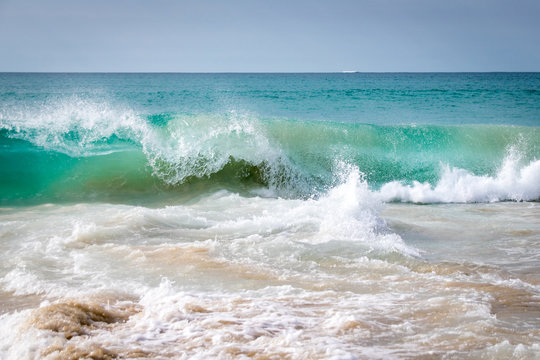 Turquoise waves breaking on a sandy tropical beach