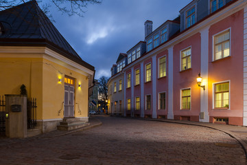 Old Tallinn architecture ensemble. The narrow street illuminated at the evening.