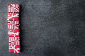 Fototapeta premium Red gift boxes on dark stone background with copy space.