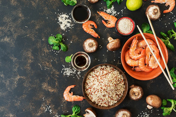 Obraz na płótnie Canvas Background with ingredients of Asian cuisine brown rice, shrimp and mushrooms. Top view, copy space
