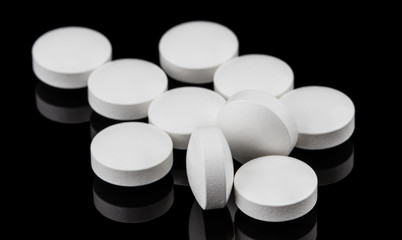 close up on a group of round shape white pill on the dark background