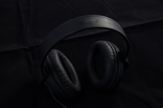 Black classic headphones on black background
