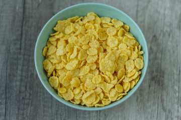 corn flakes are poured into a green plate