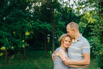 Fototapeta premium Horizontal portrait of a husband hugging his beautiful pregnant wife