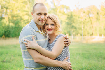 Fototapeta premium Horizontal portrait of a husband hugging his beautiful pregnant wife