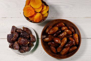 Dried apricots and dates fruit on white wooden table. Top view