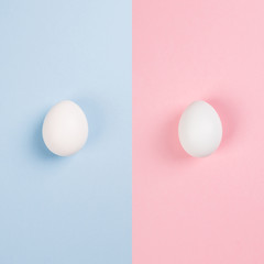 White eggs on blue and pink background. Сoncept gender stereotypes, role of man and woman in society