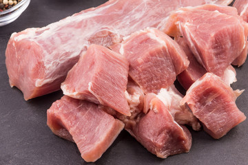 Raw pork tenderloin close-up and chopped pieces of meat for extinguishing