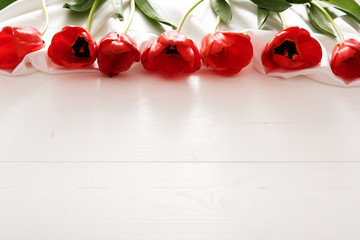 Colorful tulips on white wooden table with copy space