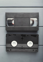 Video cassettes on gray wooden surface . Back to the past