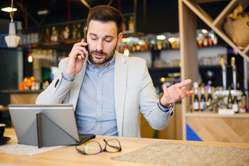 Serious young businessman talking on a phone